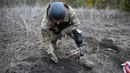 Andriy Ilkiv, seorang penjinak ranjau dari kepolisian nasional Ukraina, yang kehilangan kakinya tahun lalu akibat ledakan ranjau, mencari ranjau di sebuah ladang di distrik Izyum, wilayah Kharkiv, di tengah invasi Rusia ke Ukraina pada 24 Oktober 2023. (SERGEY BOBOK / AFP)