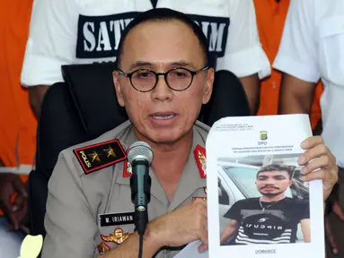 Kapolda Metro Jaya, Irjen Pol M Iriawan menunjukkan foto tersangka kasus kekerasan yang masih buron saat rilis di Jakarta, Kamis (13/7). Polisi menangkap empat orang dan masih memburu satu tersangka lainnya. (Liputan6.com/Helmi Fithriansyah)