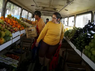 Seorang wanita mencari buah-buahan saat berbelanja di dalam pasar bus 'Sacolao' di Santa Teresa, Rio de Janeiro, Brasil, Selasa (7/7/2015). Pasar bus ini menjual sayur dan buah-buahan dengan harga yang terjangkau. (REUTERS/Pilar Olivares)