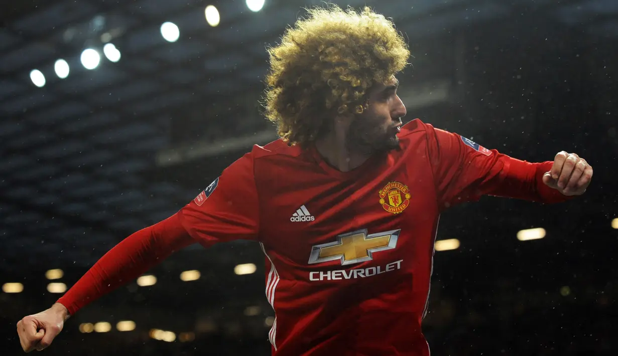 Gelandang MU, Marouane Fellaini melakukan selebrasi usai mencetak gol ke gawang Wigan Athletic pada pertandingan Piala FA di Stadion Old Trafford, Inggris (29/1). MU menang atas Wigan 4-0. (AP Photo/Rui Vieira)