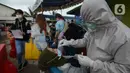 Petugas medis mengambil sampel lendir seorang perempuan untuk tes usap atau Swab Antigen di Pelabuhan Kali Adem, Jakarta, Kamis (31/12/2020). Pemeriksaan swab antigen wisatawan yang akan libur Tahun Baru di Kepulauan Seribu dilakukan untuk mencegah penyebaran COVID-19. (merdeka.com/Imam Buhori)