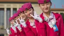 Para pemandu berpose  di lapangan Tiananmen selama sesi penutupan Kongres Partai Komunis ke-19 di Beijing (24/10). Sejumlah wanita cantik ini ditugaskan untuk memandu para peserta kongres. (AFP Photo/ Nicolas Asfouri)