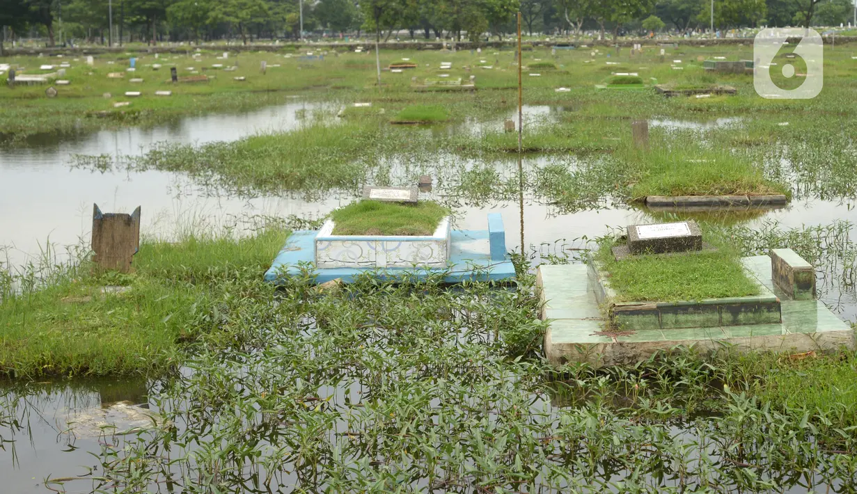 Banjir merendam Tempat Pemakaman Umum (TPU) Semper, Jakarta, Kamis (11/11/2021). Ratusan makan di TPU Semper terendam banjir akibat hujan deras yang menguyur Ibu Kota beberapa hari lalu. (merdeka.com/Imam Buhori)