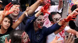 Sejumlah orang berjalan dengan riasan zombie dalam parade "Zombie Walk" di Sao Paulo, Brasil, Senin (2/11/2015). (REUTERS / Paulo Whitaker)