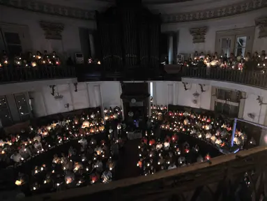 Jemaat memanjatkan doa dengan menyalakan lilin pada Misa Malam Natal di Gereja Immanuel, Jakarta, Senin (24/12). Misa Natal tahun ini mengangkat tema Membangun Spiritualitas Damai yang Menciptakan Perdamaian. (Merdeka.com/Iqbal S. Nugroho)