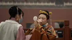 Seorang wanita dengan pakaian tradisional memeriksa riasannya saat dia berdiri di pintu masuk ke Kota Terlarang pada hari kedua Tahun Baru Imlek di Beijing (13/2/2021). Tahun Baru Imlek menandai Tahun Sapi pada 12 Februari. (AFP Photo/Noel Celis)