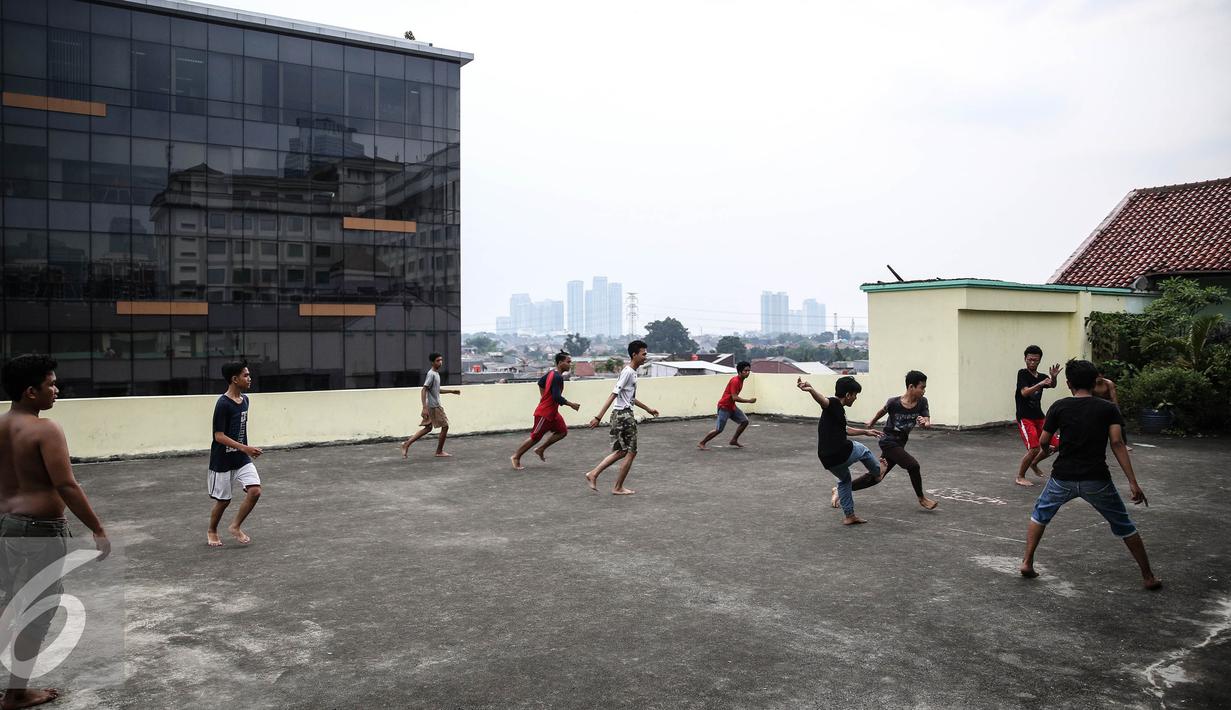 Sejumlah remaja bermain futsal di atas gedung di Pasar Mampang, Jakarta, Rabu (12/7). Sehingga anak-anak dari kalangan ekonomi yang kurang mampu terpaksa memanfaatkan tempat yang bukan semestinya. (Liputan6.com/Faizal Fanani)