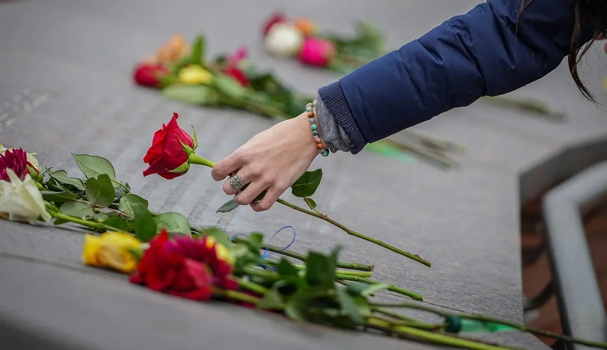 Kelli Muster dari Santa Rosa, California meletakkan bunga mawar merah di Columbine Memorial di Clement Park pada peringatan 25 tahun penembakan di sekolah tersebut pada 20 April 2024 di Littleton, Colorado. (Marc Piscotty/Getty Images North America/Getty Images via AFP)