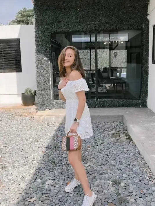 <p>Mini dress off shoulder bewarna putih yang dipadukan dengan sneakers warna senada membuat bodi langsing Caitlin Halderman makin menawan. (Instagram/caitlin halderman)</p>