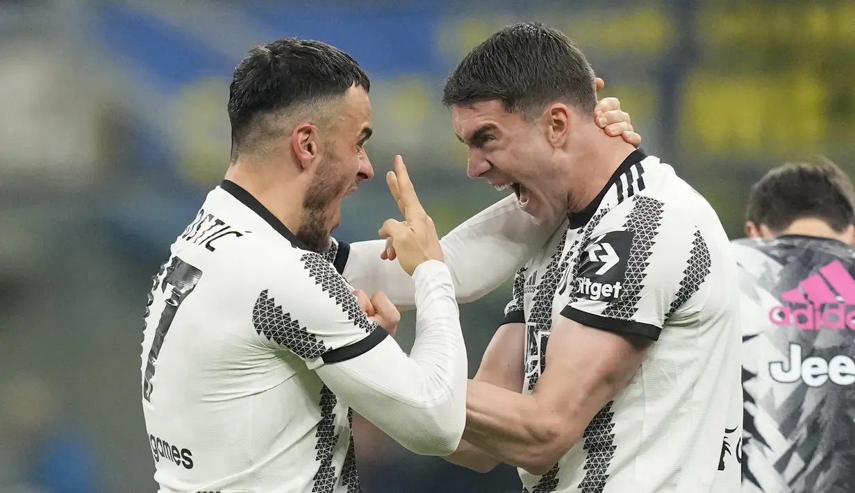 Gelandang Juventus, Filip Kostic berselebrasi dengan Dusan Vlahovic setelah mencetak gol pembuka timnya ke gawang Inter Milan pada laga Liga Italia atau  Serie A 2022/2023 giornata ke-27 di Stadio Giuseppe Meazza, Senin (20/3/2023) dini hari WIB. (AP Photo/Antonio Calanni)