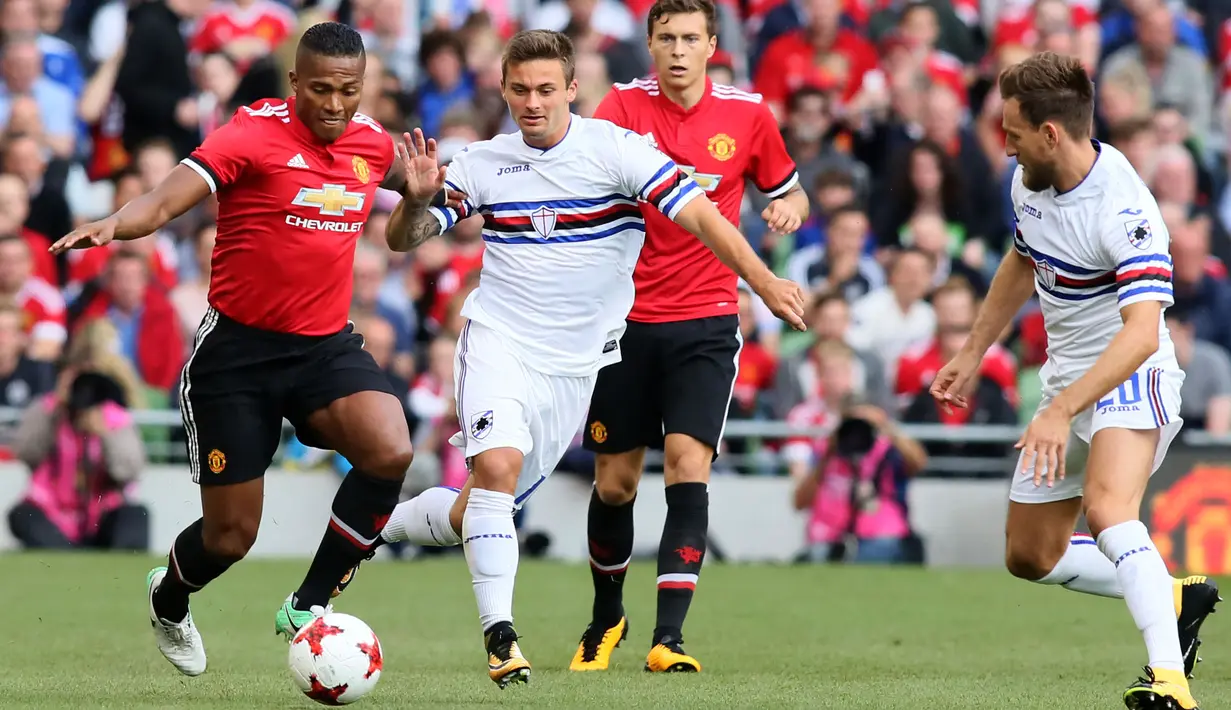 Bek Manchester United, Antonio Valencia membawa bola dari kejaran dua pemain Sampdoria saat pertandingan persahabatan pra musim di stadion Aviva di Dublin (2/8). MU menang atas Sampdoria dengan skor 2-1. (AFP Photo/Paul Imith)