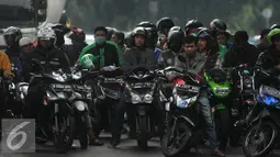 Pengendara sepeda motor berteduh di bawah flyover saat hujan turun, Jakarta, Rabu (13/7). Petugas kepolisian akan menerapkan tilang dengan denda maksimal Rp250.000 untuk pengendara yang berteduh di bawah flyover. (Liputan6.com/Gempur M Surya) 