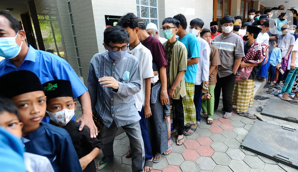 Warga mengantre untuk mendapatkan nasi kota usai melaksanakan Sholat Jumat di Masjid Wihdatul Ummah, Cinere, Depok,Jumat (27/5/2022). Setiap minggunya setelah kegiatan Sholat Jumat lebih dari 700 nasi kotak yang merupakan sumbangan dari donatur jamaah masjid dan warga sekitar dibagikan kepada warga dalam rangka Jumat Berkah. (merdeka.com/Arie Basuki)