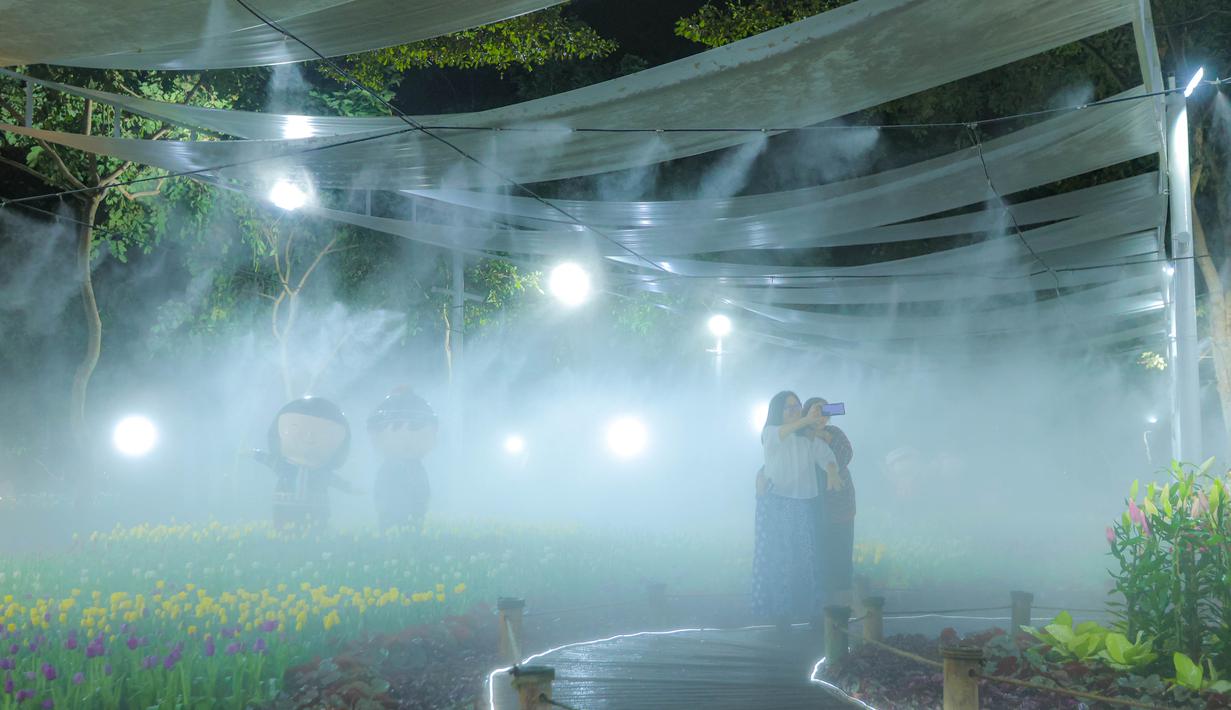 Pengunjung menikmati suasana Charming Chiang Mai Flower Festival di Chiang Mai, Thailand, pada Kamis (11/12/2025). Charming Chiang Mai Flower Festival merupakan festival tahunan di Chiang Mai yang menampilkan parade bunga berwarna-warni, rangkaian bunga raksasa, serta karya seni hortikultura khas Thailand Utara. (Bola.com/Bagaskara Lazuardi)