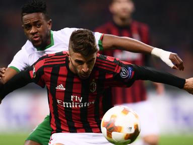 Pemain AC Milan, Fabio Borini  dan gelandang Ludogorets Razgrad, Virgil Roy Misidjan berebut bola pada leg kedua babak 32 besar Liga Europa, di San Siro, Milan, Kamis (22/2). Milan menang tipis 1-0 sehingga lolos ke babak 16 besar. (MARCO BERTORELLO/AFP)