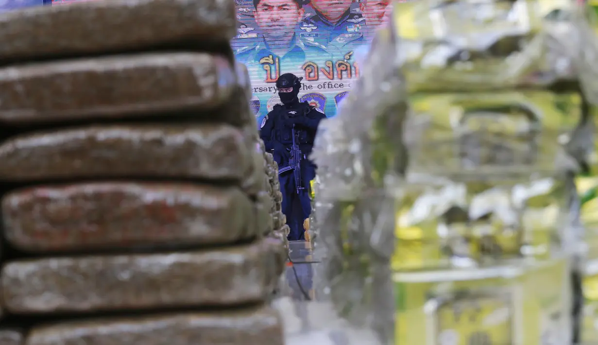 Petugas berjaga di dekat narkoba yang disita kepolisian Thailand dalam konferensi pers di Bangkok, Selasa (3/4). Thailand melakukan salah satu penyitaan terbesar narkoba jenis sabu senilai 700 juta baht atau sekitar Rp 308 miliar. (AP/Sakchai Lalit)