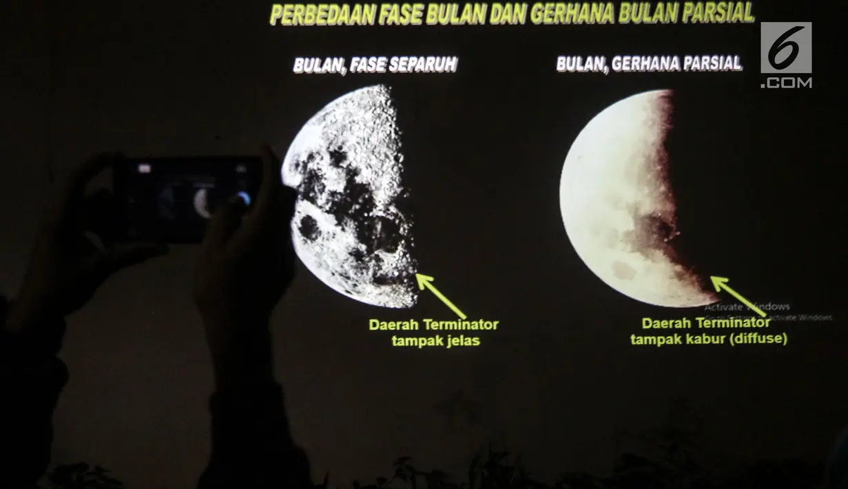 Warga mengambil gambar layar yang berisi penjelasan tentang gerhana bulan di Taman Ismail Marzuki, Jakarta, Rabu (17/7) dini hari. Gerhana bulan terakhir dalam tahun 2019 ini merupakan fenomena jenis gerhana bulan parsial, karena masih ada yang tampak sebagian. (Liputan6.com/Johan Tallo)