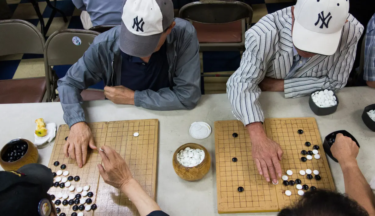 Pria bermain Baduk, versi Go Korea, di pusat Layanan Komunitas Korea di New York (10/8). Sekitar 100.000 orang Korea tinggal di New York City. (AFP Photo/Don Emmert/To Go With AFP STORY by Jennie Matthew, NKorea-US-nuclear-diaspora)