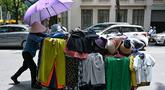 Seorang pedagang kaki lima mendorong gerobak pakaian di Hanoi, Vietnam pada 1 Juni 2023. Ribuan pedagang kaki lima, sebagian besar wanita, di ibukota Vietnam tidak punya pilihan selain bekerja melalui serangkaian gelombang panas yang melanda bagian utara negara itu dalam beberapa minggu terakhir. (Photo by Nhac NGUYEN / AFP)
