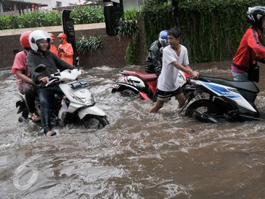 Pengendara mendorong kendaraanya yang mogok akibat menerobos banjir di kawasan Kemang, Jakarta Selatan, Rabu (26/4). Hujan deras yang menguyur kawasan Jakarta menyebabkan banjir di sejumlah kawasan. (Liputan6.com/Yoppy Renato)