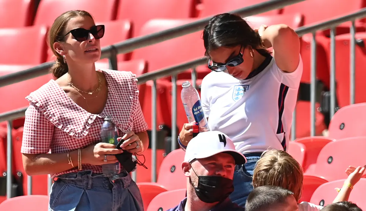 Annie Kilner, tunangan pemain Inggris Kyle Walker (kanan) merapikan rambutnya saat berbincang Coleen Rooney, istri mantan pemain Inggris Wayne Rooney selama pertandingan grup D antara Inggris melawan Kroasia di stadion Wembley di London, Minggu (13/6/2021). (AFP/Pool/Glyn Kirk)
