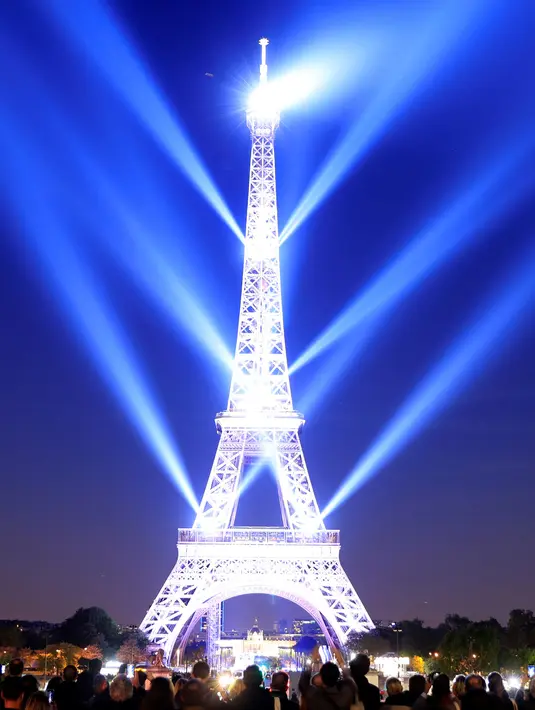 Menara Eiffel diterangi selama pertunjukan cahaya untuk perayaan ulang tahunnya ke-130 tahun di Paris, Rabu (15/5/2019). Paris memberikan ucapan ulang tahun kepada Menara Eiffel dengan pertunjukan laser yang rumit menelusuri kembali sejarah 130 tahun monumen itu. (REUTERS/Gonzalo Fuentes)