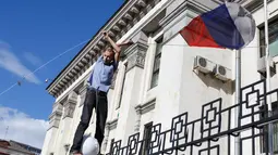 Massa aksi terlihat menurunkan bendera Rusia yang berkibar di halaman Kedutaan Besar di Kiev, Ukraina, (14/6/2014). (REUTERS/Oleg Pereverzev)