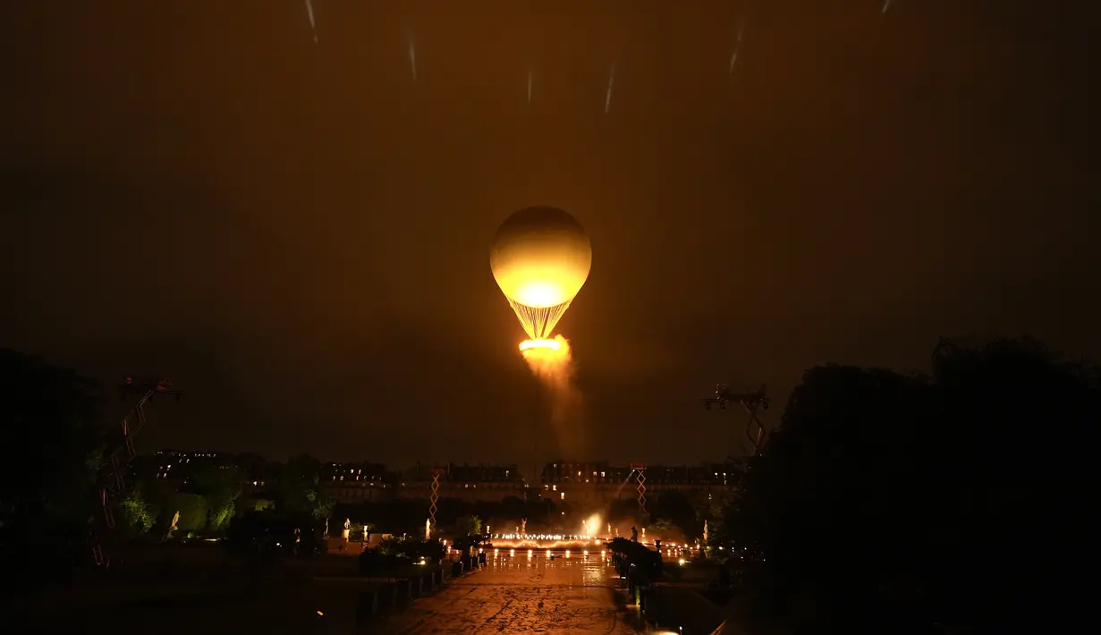 Kancah Api Olimpiade dibawa oleh balon udara sebagai penghormatan kepada penerbangan balon udara hidrogen pertama di dunia yang berlangsung di Tuileries pada Desember 1783.  (AP Photo/Rebecca Blackwell)