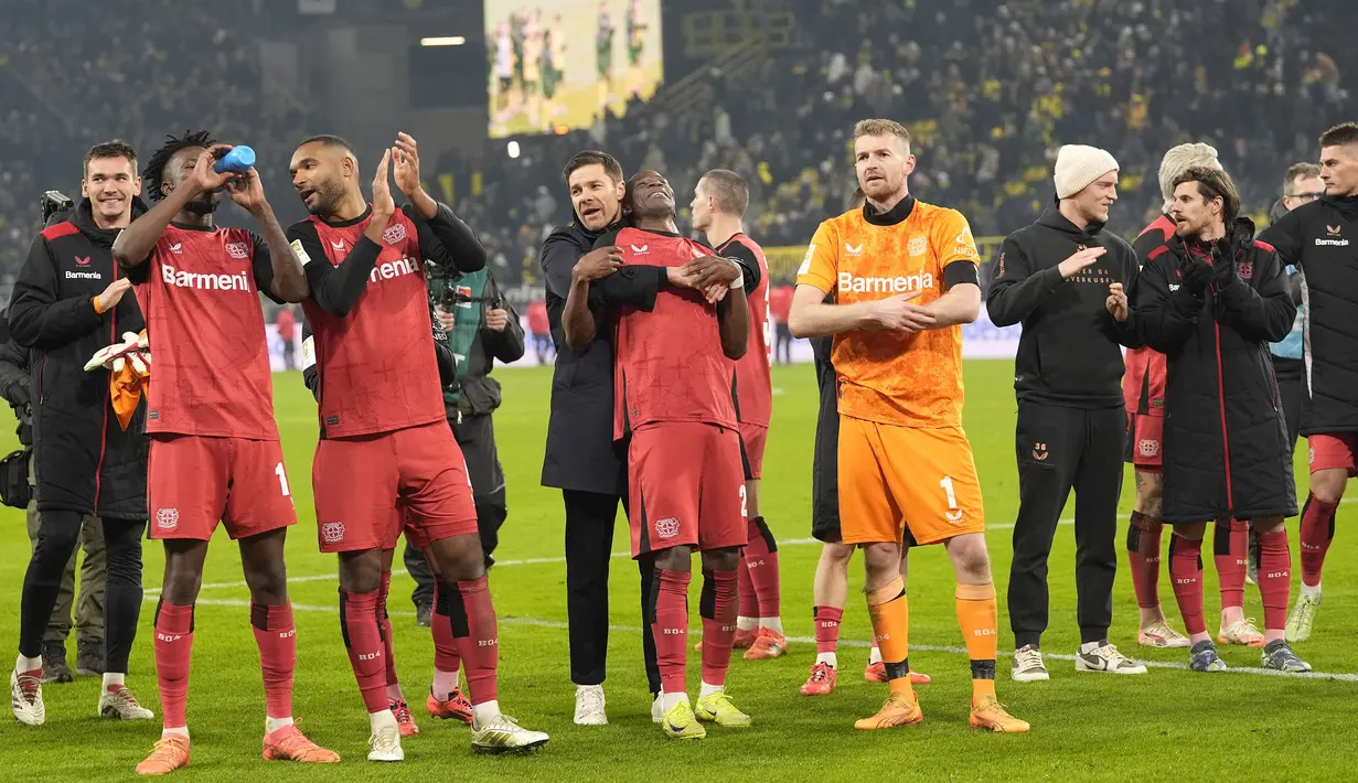 Pelatih Bayer Leverkusen, Xabi Alonso bersama para pemain merayakan kemenangan atas Bayern Munchen pada laga lanjutan Bundesliga 2024/2025 di Signal Iduna Park, Dortmund, Jerman, Sabtu (11/01/2025) WIB. (AP Photo/Martin Meissner)