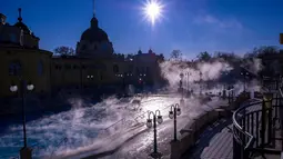 Uap air panas terlihat menyelimuti kolam air panas Szechenyi Thermal Bath di Budapest, Hongaria, 7 Januari 2017. Bersuhu sekitar 74-77 derajat celcius, air ini diyakini berkhasiat menyehatkan tubuh karena kaya akan mineral. (Bea Kallos/MTI via AP)