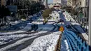 Orang-orang berjalan melewati salju di Madrid, Spanyol, Senin (11/1/2021). Ibu kota Spanyol itu berusaha bangkit kembali setelah menghadapi badai salju terburuk dalam 50 tahun terakhir yang melumpuhkan sebagian besar wilayah Spanyol tengah selama akhir pekan. (AP Photo/Manu Fernandez)