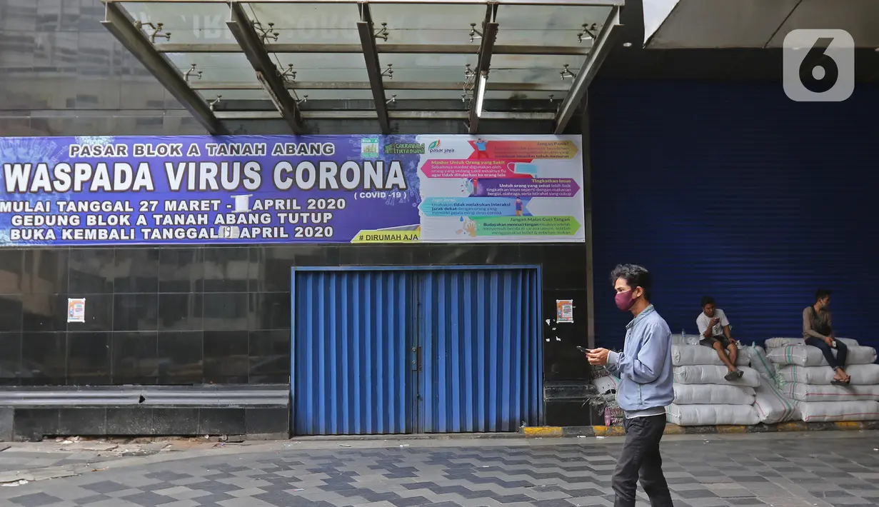 Warga berjalan melintasi Pasar Tanah Abang yang tutup di Jakarta, Senin (6/4/2020). Pemerintah Provinsi DKI Jakarta memperpanjang penutupan sementara Pasar Tanah Abang hingga 19 April 2020 sebagai bentuk pencegahan penyebaran corona COVID-19. (Liputan6.com/Herman Zakharia)