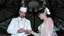 Reza Pahlevi menyematkan cincin ke jari Astrilika Lintong setelah resmi menjadi pasangan suami istri pada sore menjelang senja (28/8/2015). (Deki Prayoga/Bintang.com)