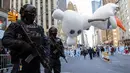 Polisi bersenjata lengkap berjaga ketika balon Olaf melayang di atas kawasan Sixth Avenue selama Parade Macy's Thanksgiving Day di New York, Kamis (22/11). Membelah jalanan kota, Parade Macy's selalu ditunggu setiap tahunnya. (AP/Mary Altaffer)