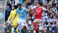 Pemain Manchester City, Rodri, berebut bola dengan pemain Arsenal, Declan Rice, dalam pertandingan Liga Inggris di Etihad, Inggris, Minggu (19/4/2026) malam WIB. (AP Photo/Dave Thompson)