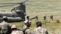 Tentara Inggris dikerahkan dari helikopter AS selama latihan militer Swift Response 22 di poligon pelatihan tentara Krivolak, Makedonia Utara, 12 Mei 2022. Latihan militer Swift Response 22 dilakukan untuk menunjukkan kemampuan negara-negara NATO siap ditempatkan di mana saja di seluruh dunia serta tentaranya dapat beroperasi bersama secara profesional dan sukses. (AP Photo/Boris Grdanoski)