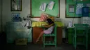 Seorang anak duduk di ruang kelas Sekolah Dasar Dona Tiburcia Carpio Malvar yang digunakan sebagai pusat evakuasi korban letusan Gunung Taal, Tanauan, Filipina, Rabu (16/1/2020). Pihak berwenang Filipina memperingatkan bahwa potensi Gunung Taal untuk kembali meletus masih tinggi. (Ed JONES/AFP)