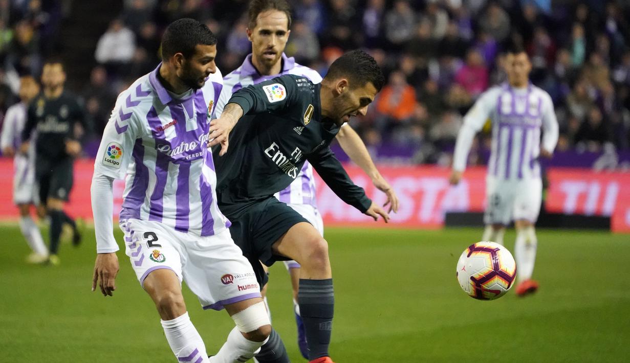 Gelandang Real Madrid, Daniel Ceballos berusaha menguasai bola dari kawalan bek Real Valladolid, Joaquin selama pertandingan lanjutan La Liga Spanyol di stadion Jose Zorrilla,Valladolid (10/3). Madrid menang 4-1 atas Valladolid. (AFP Photo/Cesar Manso)