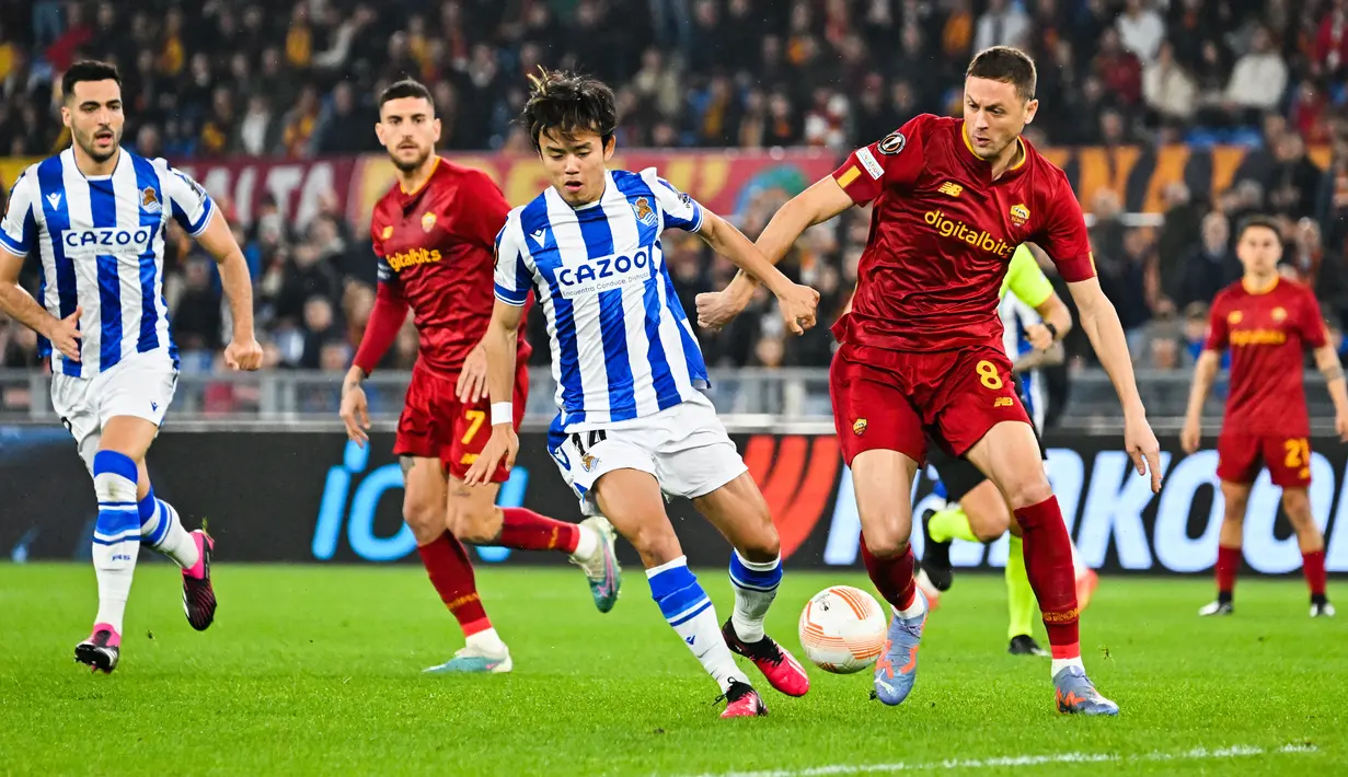 Penyerang Real Sociedad Takefusa Kubo (Tengah) berebut bola dengan gelandang AS Roma, Nemanja Matic pada laga pertama babak 16 besar Liga Europa 2022/2023 di Olimpico, Jumat (10/3/2023) dini hari WIB. Dalam lima laga terkini di semua ajang, Tim Serigala asuhan Jose Mourinho selalu menang tanpa pernah kebobolan! (Photo by Alberto PIZZOLI / AFP)