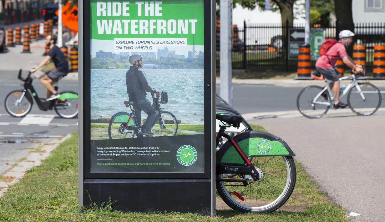 Para pesepeda melintas di depan pos parkir sepeda, Toronto, Kanada, Rabu (2/9/2020). Mulai 2 September, pelanggan layanan penyewaan sepeda Bike Share Toronto dapat menikmati perjalanan gratis di kota tersebut setiap Rabu selama September. (Xinhua/Zou Zheng)