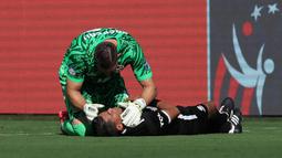 Kiper Kanada, Maxime Crepeau memberikan pertolongan kepada asisten wasit Humberto Panjoj saat mengalami pingsan pada laga Grup A Copa America 2024 antara Peru melawan Kanada di Children's Mercy Park, Kansas City, Kansas, Selasa (25/06/2024) waktu setempat. (AFP/Getty Images/Jamie Squire)