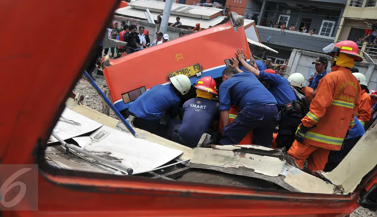 Metromini B 80 jurusan Grogol-Kalideres tertabrak di pintu perlintasan sebelum Stasiun Angke, Tambora, Jakarta Barat, Minggu (12/6/2015). Saksi menyebut Metromini tersebut nekat menerobos pintu perlintasan.(Liputan6.com/Gempur M Surya) 