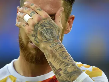 Pemain Spanyol, Sergio Ramos memiliki tato mawar dan nama ayahnya (Paqui) serta salib ditangan kirinya saat berlaga pada grup D Euro Cup 2016 melawan Kroasia di Stadion Matmut Atlantique, Bordeaux, (22/6/2016). (AFP/Loic Venance)