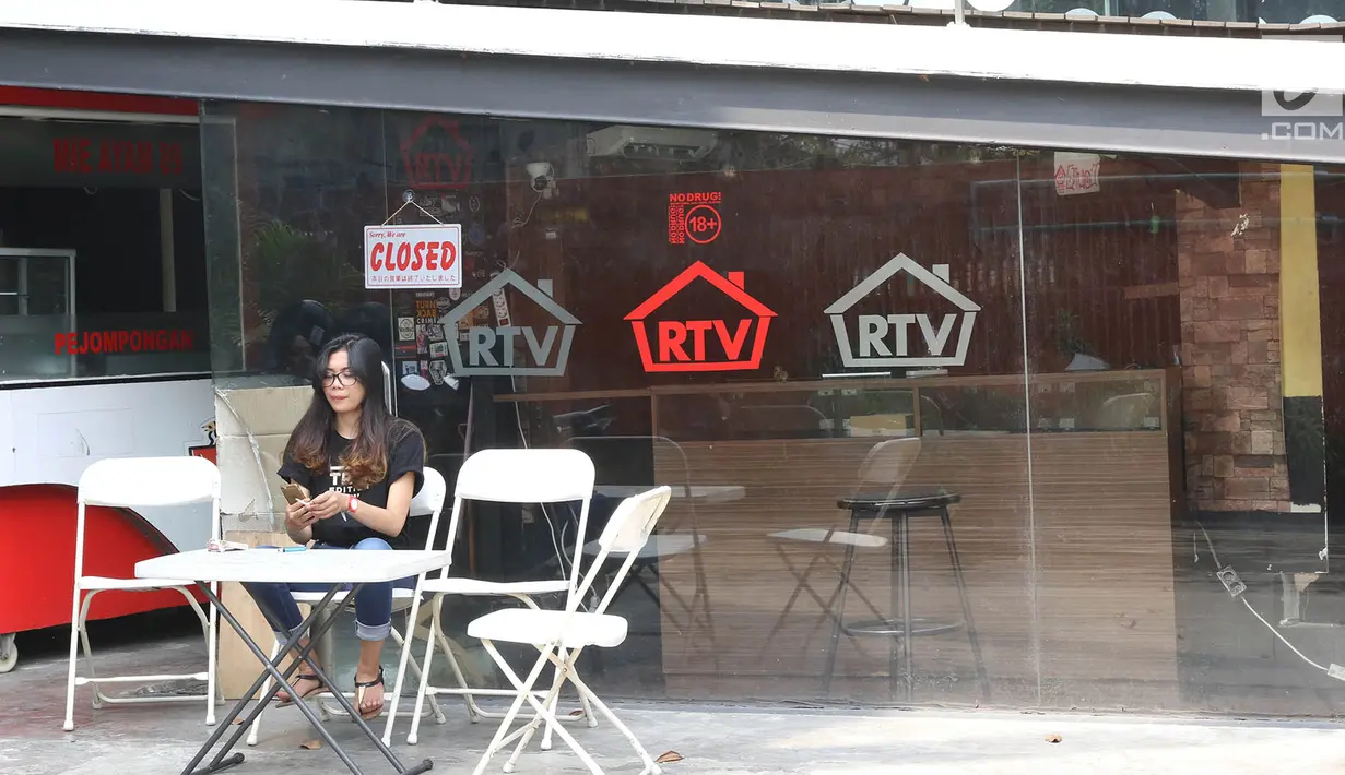 Seorang wanita duduk di depan toko Rumah Tua Vape, Pejompongan, Jakarta yang tutup, Senin (11/9). Di toko ini, Abi Qowi Suparto (20) tewas dikeroyok pegawai Rumah Tua Vape Tebet karena dituduh mencuri vape di outlet itu. (Liputan6.com/Immanuel Antonius)
