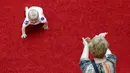 Seorang ibu memberi semangat bayinya yang sedang merangkak saat mengikuti lomba 'Balap Bayi' di Vilnius, Lithuania (1/6). Lomba ini diadakan dalam rangka memperingati Hari Anak Internasional. (REUTERS/Ints Kalnins)