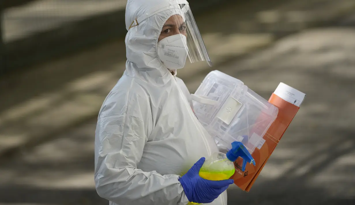 Pekerja Lisbon Civil Protection membawa botol desinfektan dan kotak plastik untuk kertas suara tiba di panti jompo di Lisbon, 25 Januari 2022. Pekerja kota se-Portugal mengunjungi panti jompo dan orang-orang dalam isolasi guna mengumpulkan suara untuk Pemilu 30 Januari mendatang. (AP/Armando Franca)