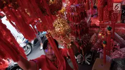 Pengunjung tengah memilih pernak-pernik Imlek di Glodok, Jakarta, Senin (22/1). Jelang perayan imlek sejumlah pedagang mulai menyajikan hiasan untuk merayakan Imlek 2018. (Liputan6.com/Angga Yuniar)