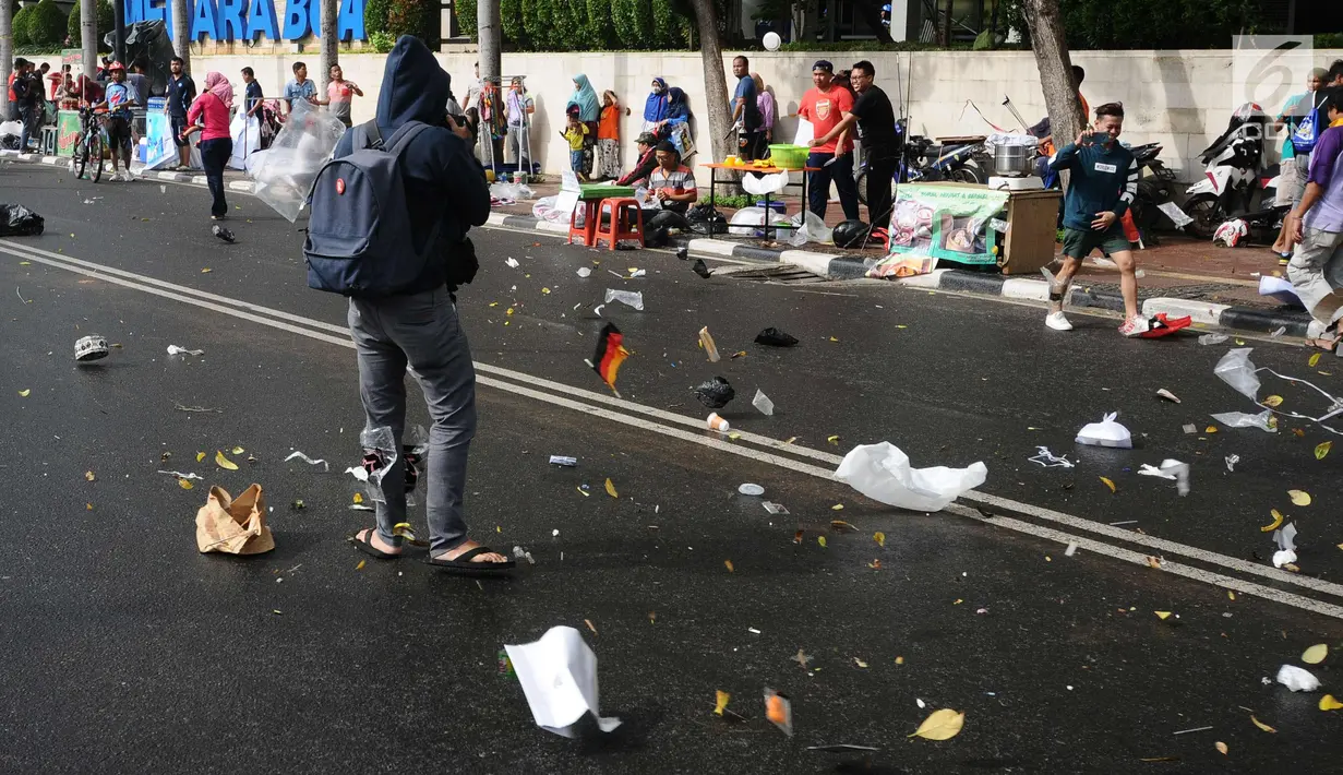 Sampah berserakan akibat hembusan angin kencang di sekitar Bundaran Hotel Indonesia, Jakarta, Minggu (26/11). Angin kencang dan gerimis terjadi saat kegiatan Hari Bebas Kendaraan, Minggu pagi. (Liputan6.com/Helmi Fithriansyah)