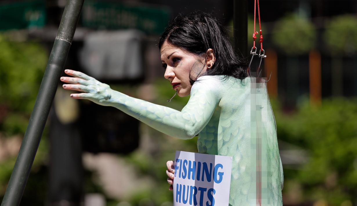 Seorang wanita bernama Victoria Lemeow menggelar aksi menolak penangkapan ikan di Seattle, AS, Senin (5/6). Aksi yang disponsori PETA  ini sebagai protes terhadap SeaWeb Seafood Summit yang diadakan di kawasan tersebut. (AP Photo / Elaine Thompson)