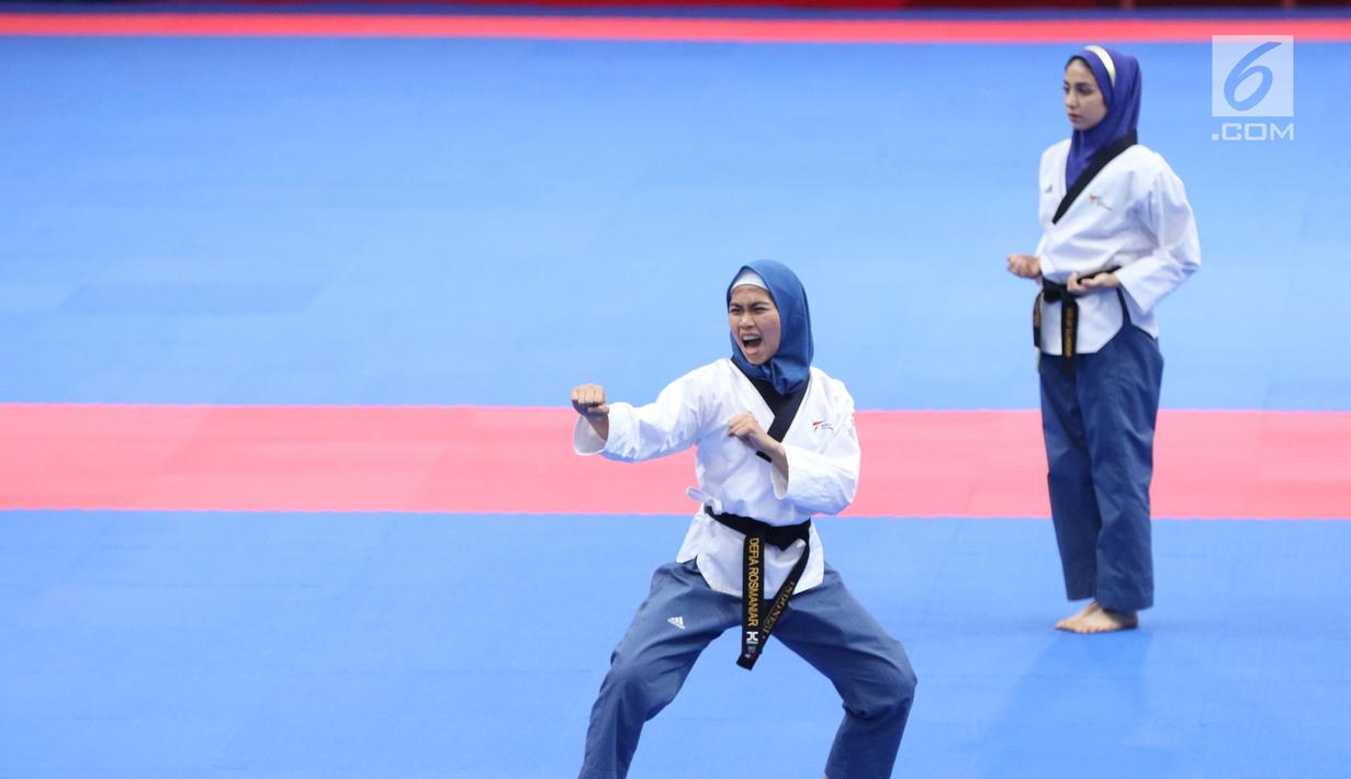 Atlet Taekwondo putri Indonesia, Defia Rosmaniar (kiri) saat beraksi melawan Salahshouri Marjan (Iran) pada Final Women Individual Poomsae di JCC, Jakarta, Minggu (19/8). Defia Rosmaniar berhasil meraih emas. (Liputan6.com/Helmi Fithriansyah)